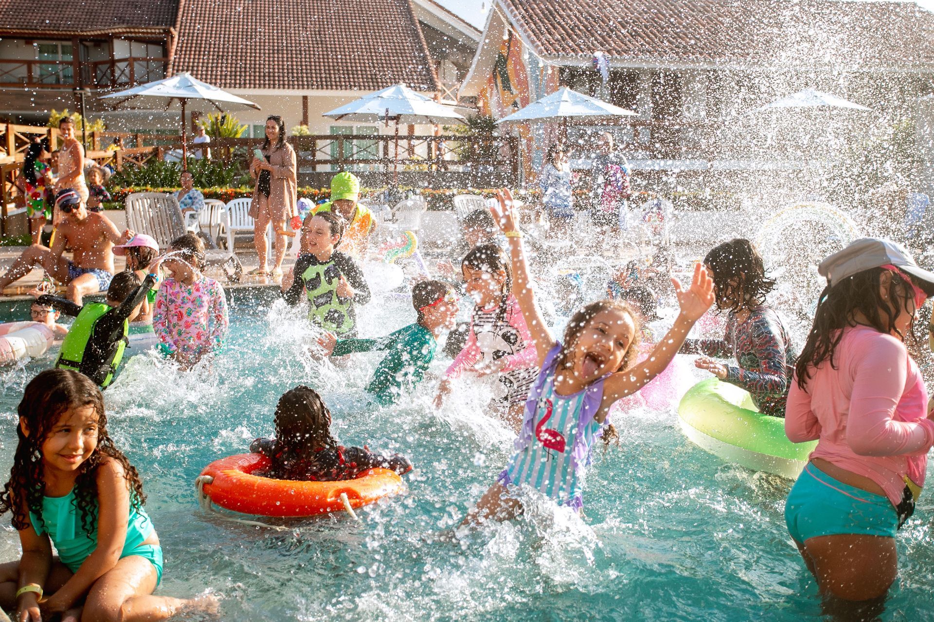 três personagens fantasiados de coelho da Páscoa com roupas coloridas e detalhes festivos posando em restaurante do resort decorado com balões e elementos temáticos
