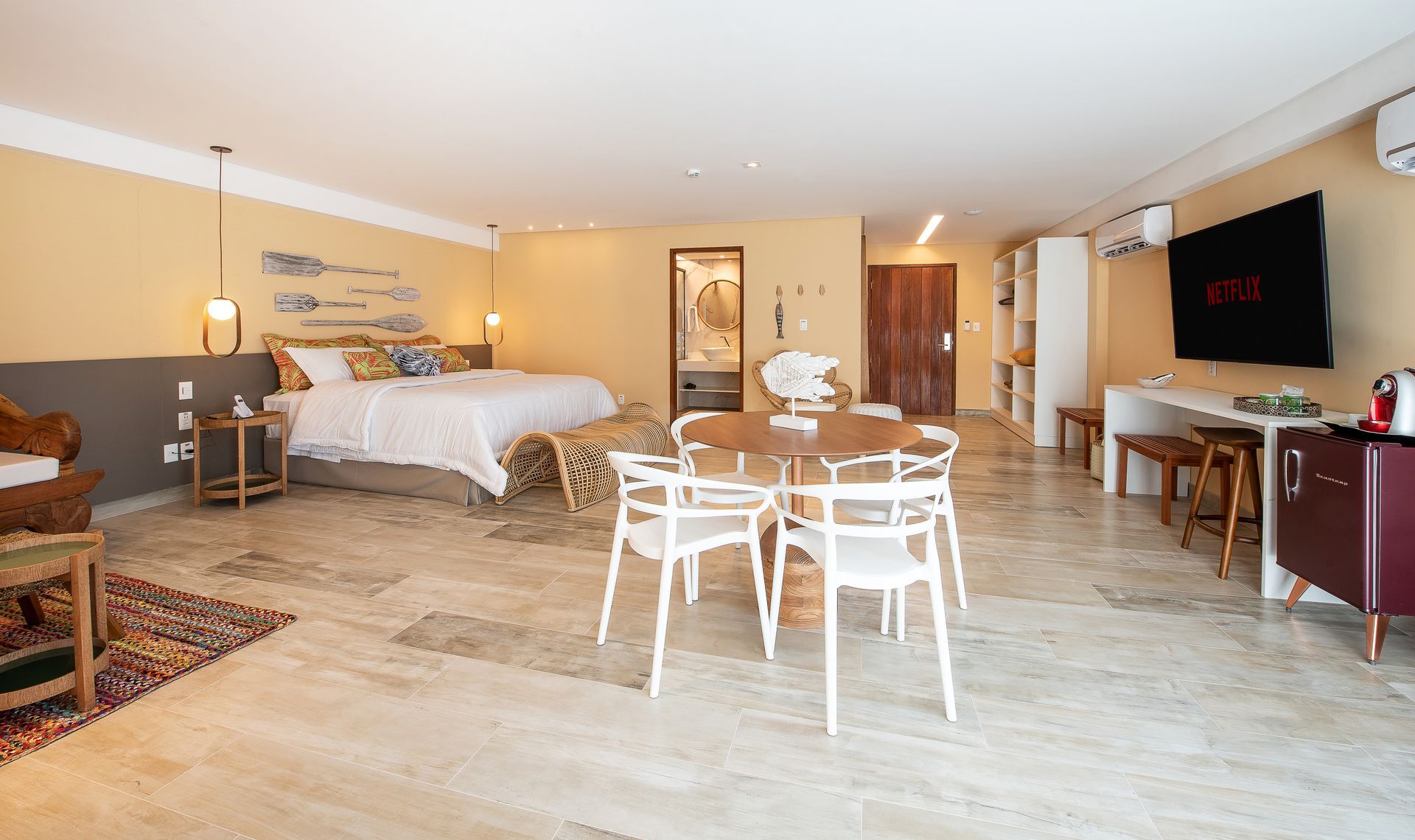 Quarto da categoria Master, super sofisticado, com cama king size, mesa com cadeiras e televisão.