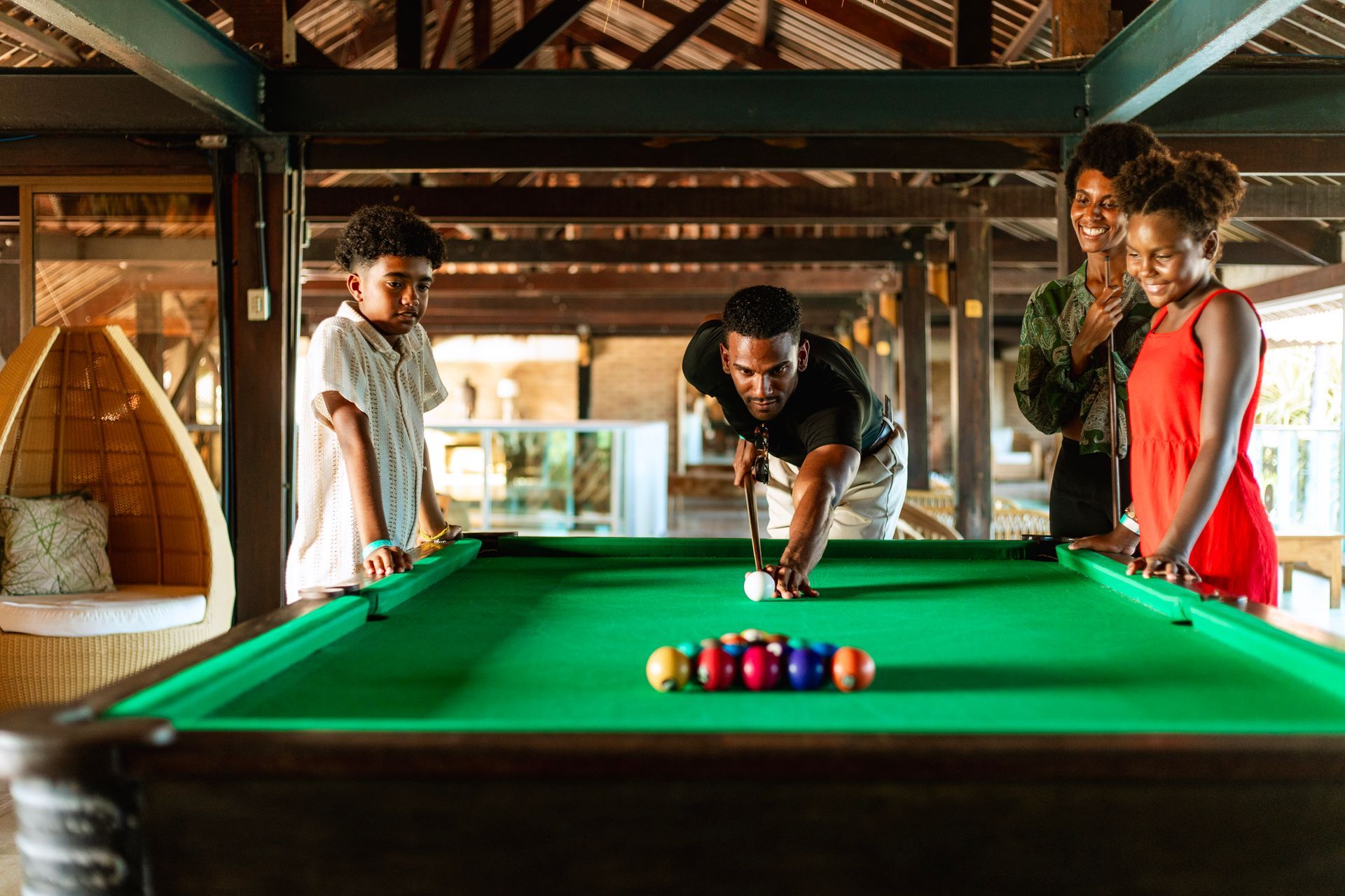 personagens fantasiados de coelho da Páscoa liderando grupo de crianças em atividade ao ar livre no resort, com área externa, coqueiros e hóspedes ao fundo.