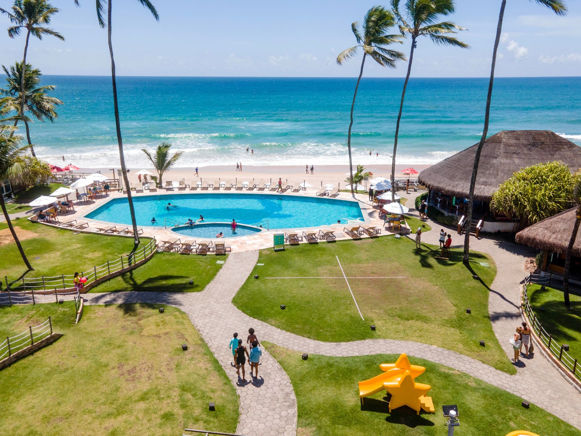 Vista aérea do Armação Resort em Porto de Galinhas, com piscina, jardins e acesso direto à praia à beira-mar 