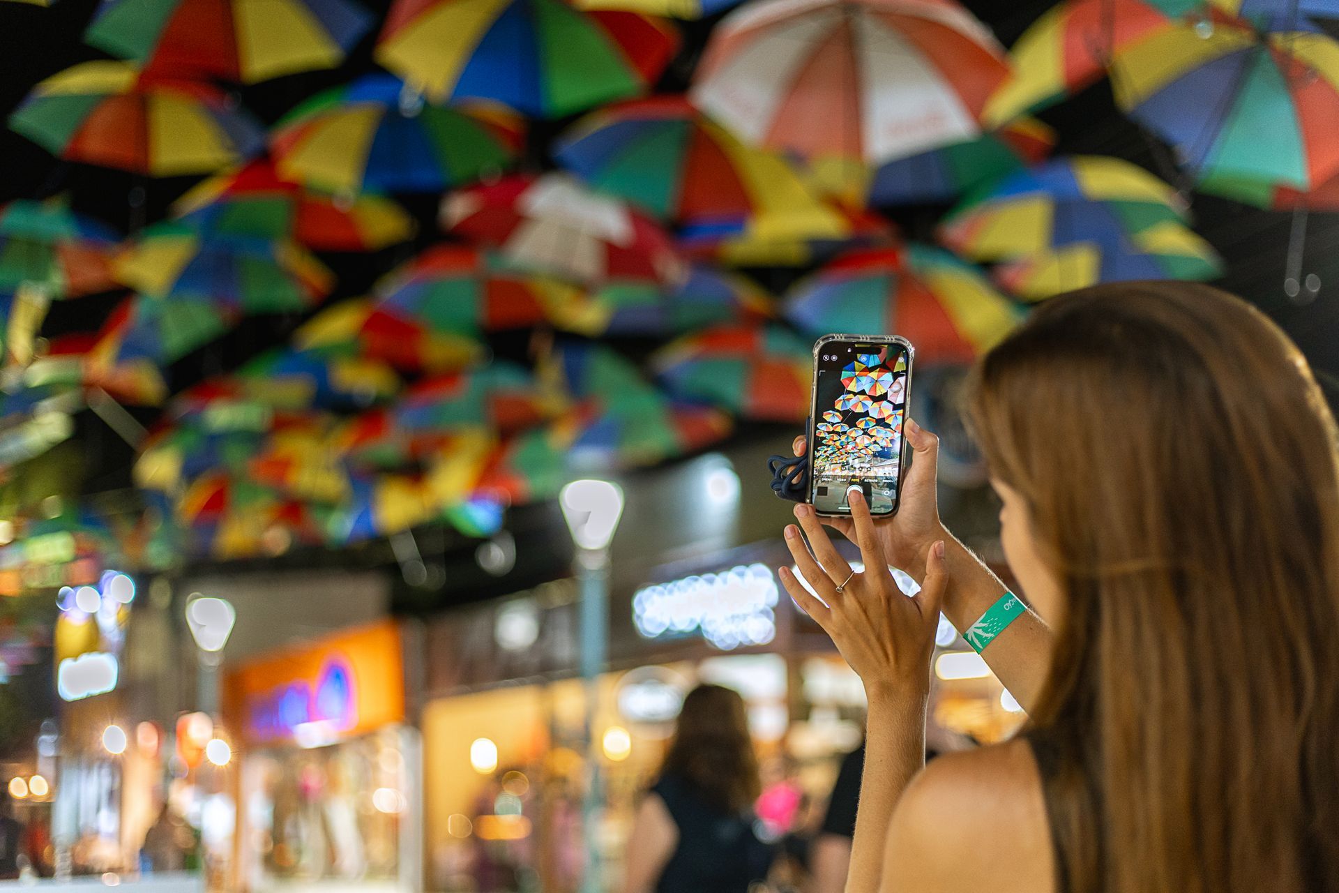 casal reunido à mesa em restaurante do resorts com janelas e vista para área verde, brindando com sucos e pratos servidos enquanto um bebê observa sentado ao lado na cadeirinha.