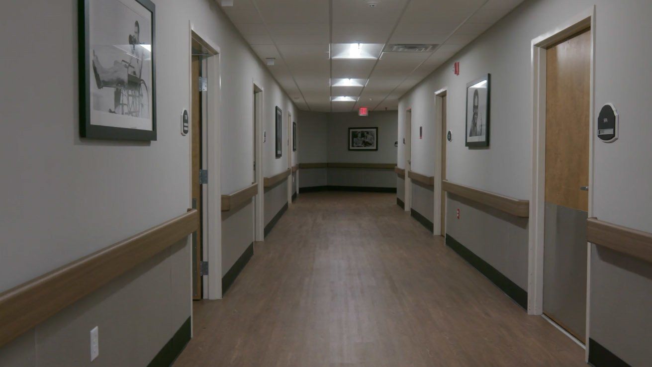 A long hallway in a hospital with a picture of a man on the wall