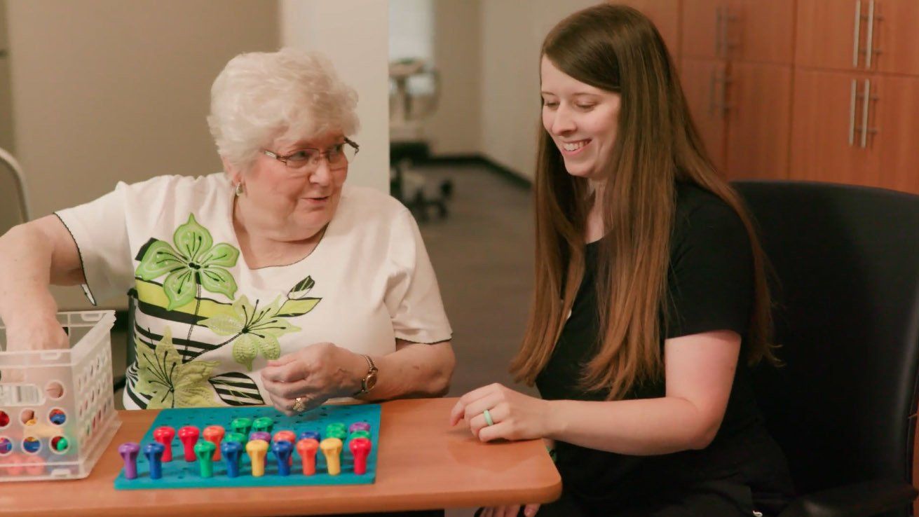 Two women are sitting at a table playing a game.