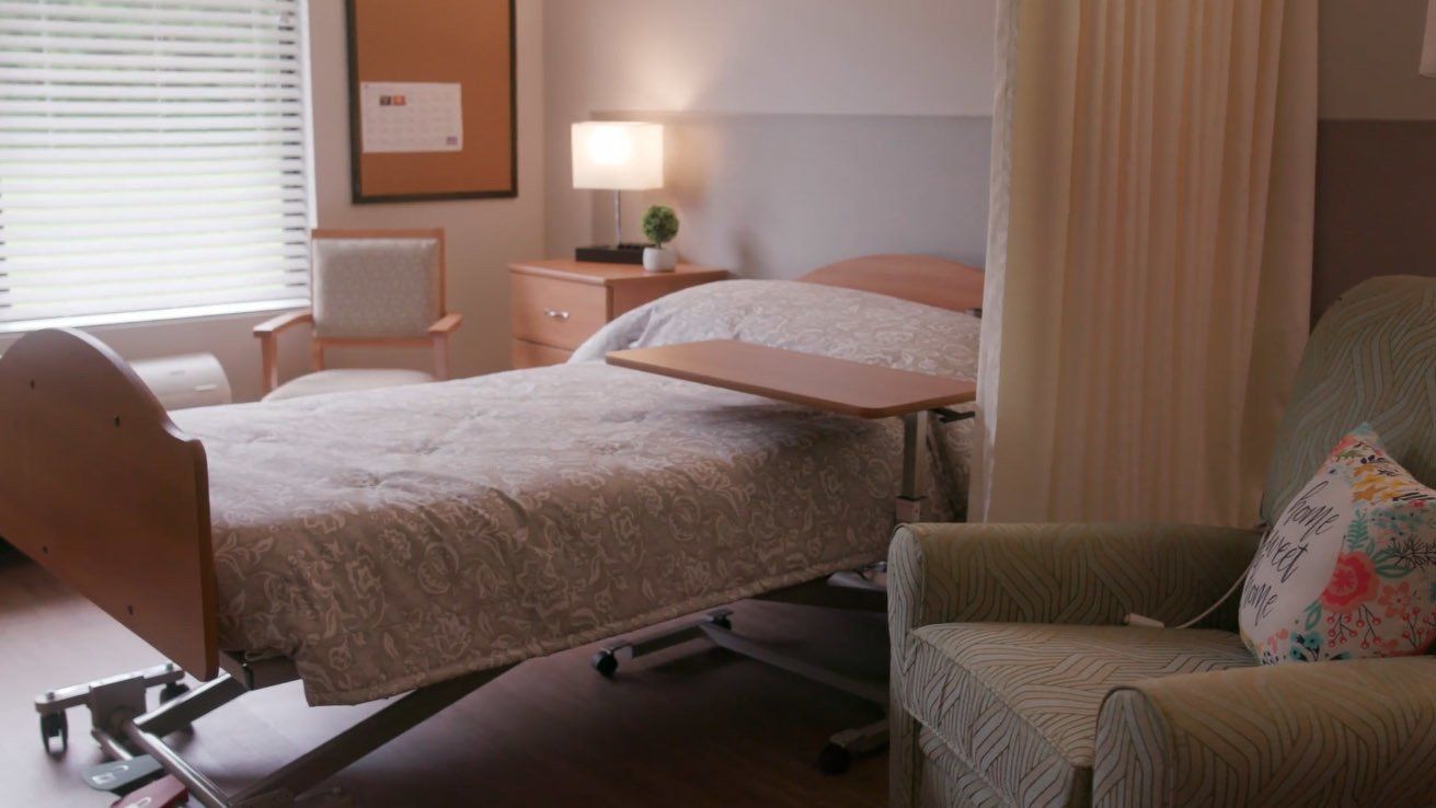A hospital room with a bed and a chair