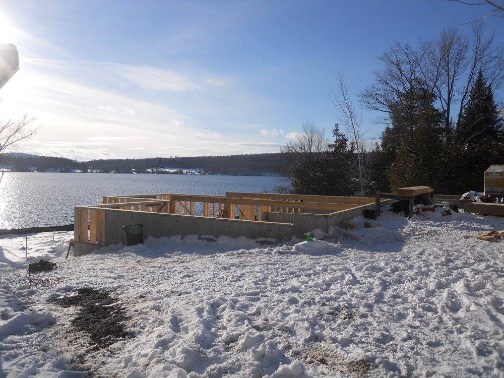 A snowy landscape with a lake in the background
