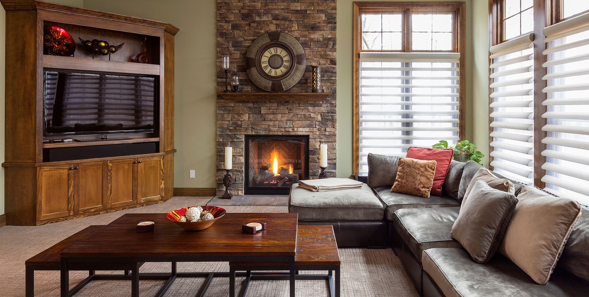 A cozy living room with a fireplace, couch, coffee table and television