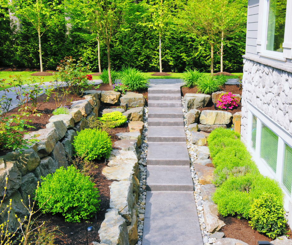 The yard of a Vermont home featuring various plants, shrubs, flowers and stone path