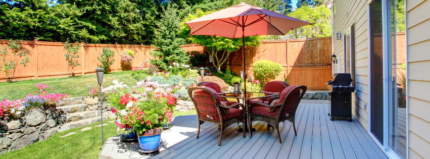 Outdoor furniture, plants and a grill on the back patio of a Vermont home