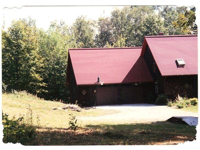 A house with a red roof is surrounded by trees