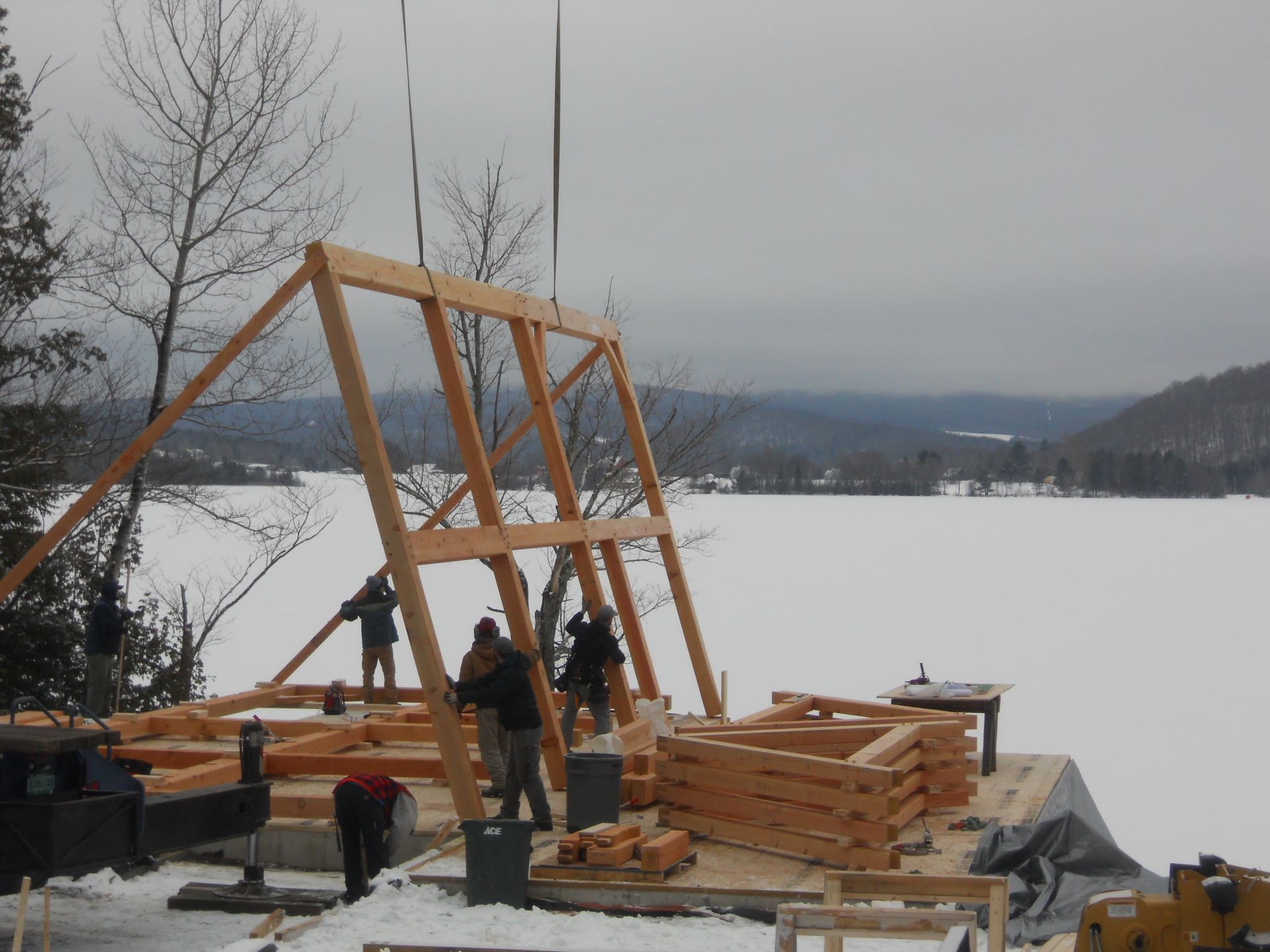 A large wooden structure is being built in the snow