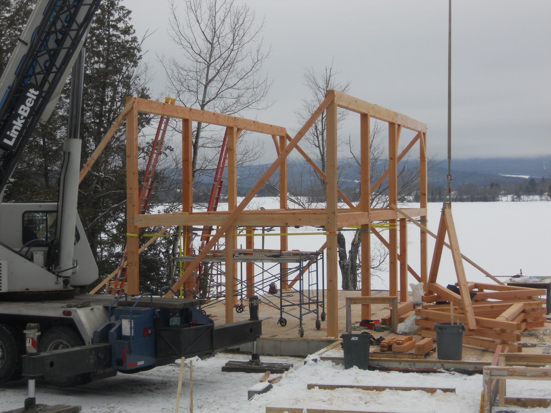 A crane is being used to build a house in the snow
