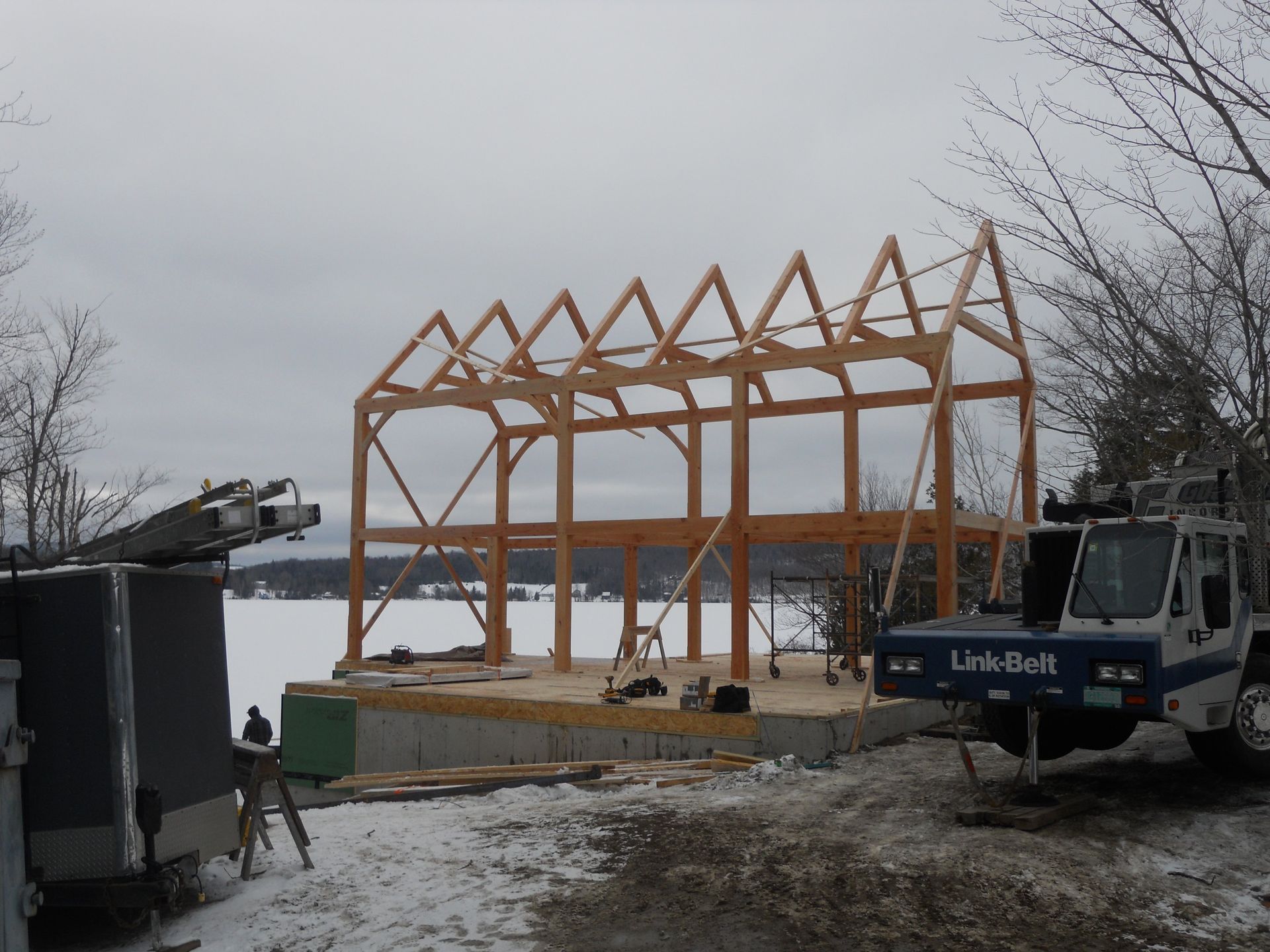 A link-box truck is parked in front of a building under construction