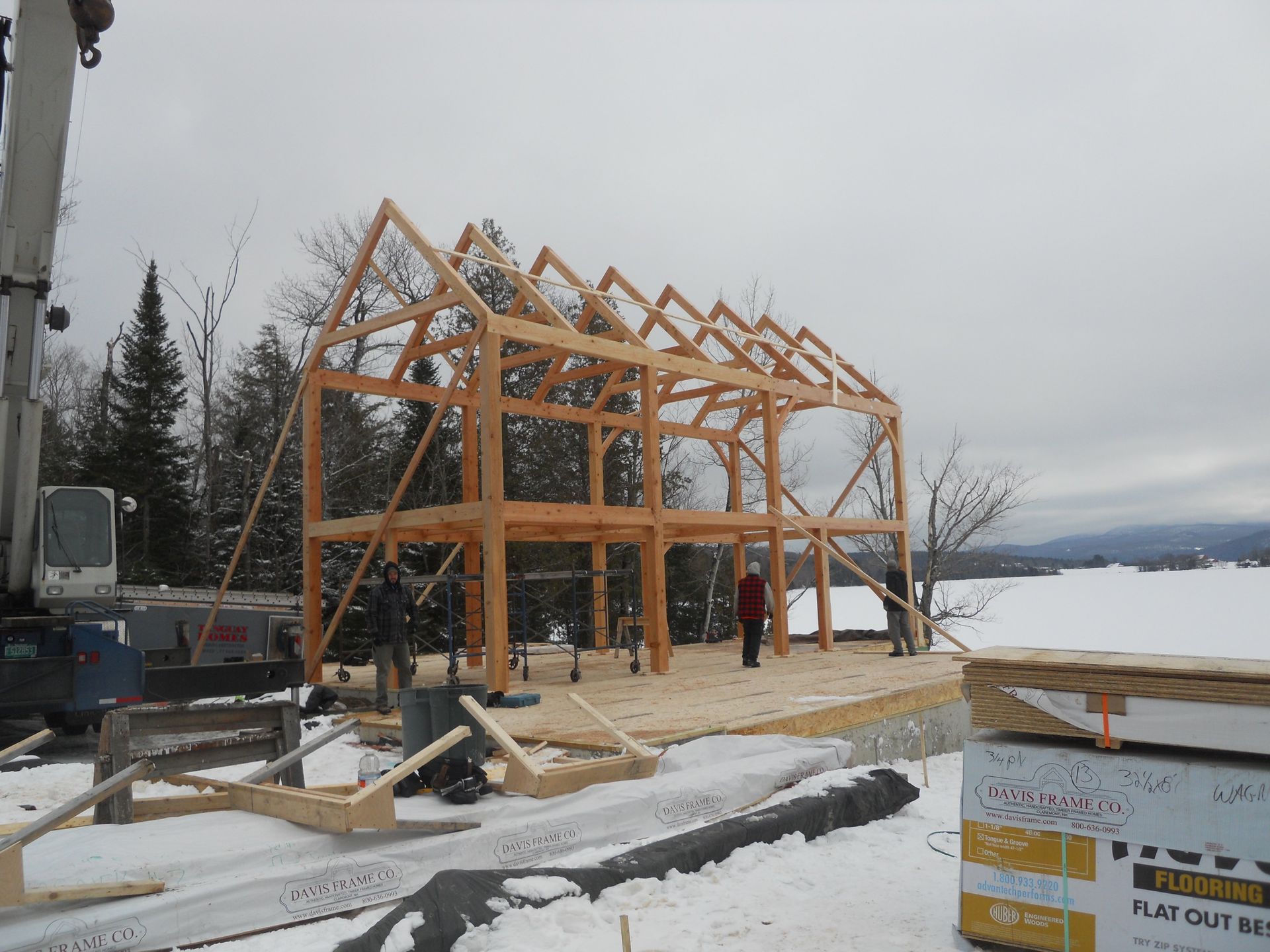 A large wooden structure is being built in the snow