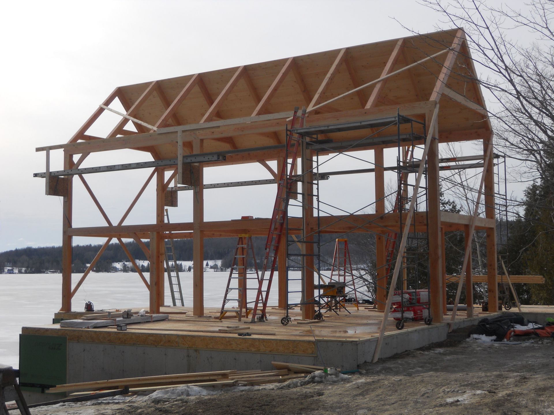 A large wooden structure is being built in the snow