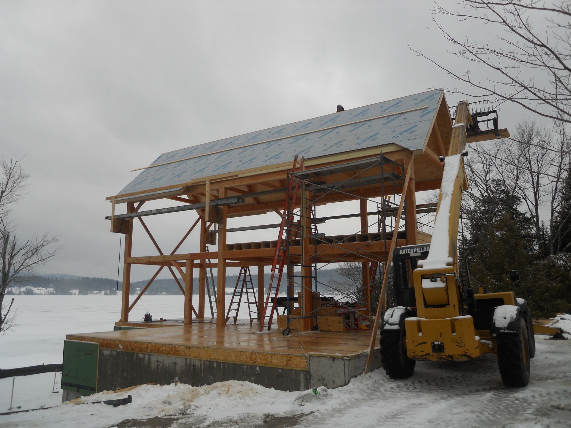 A yellow forklift is parked in front of a building under construction