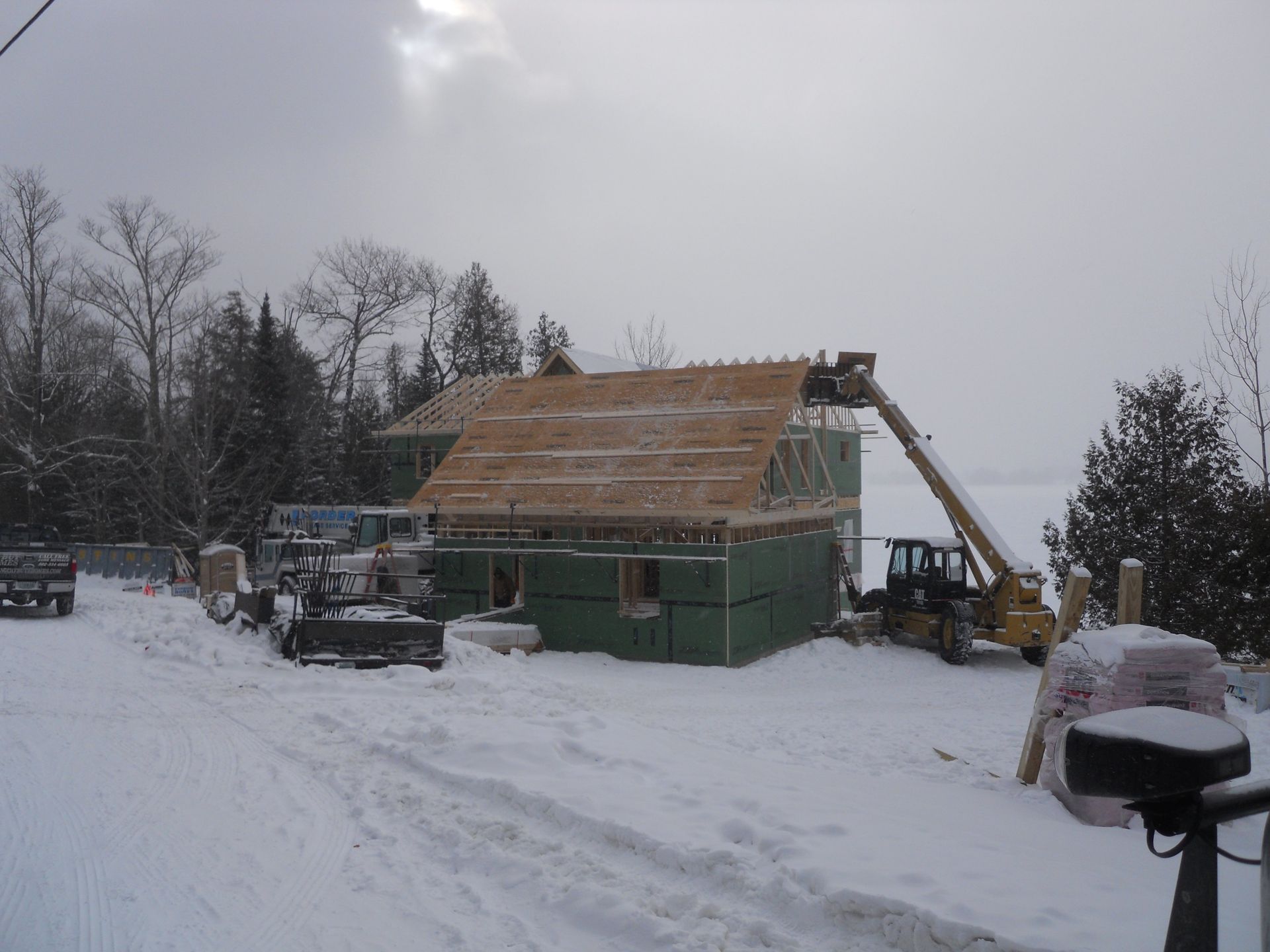 A house under construction is covered in snow