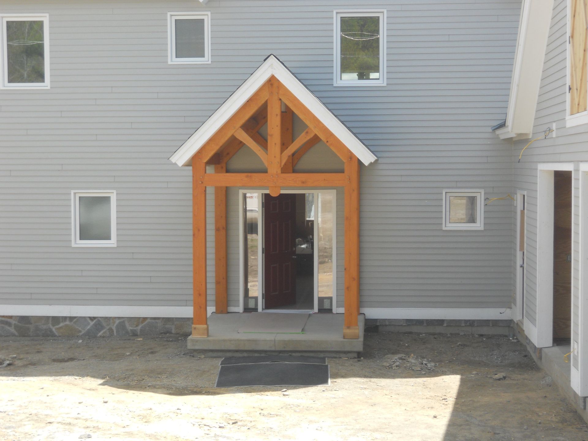 A gray house with a wooden porch over the front door