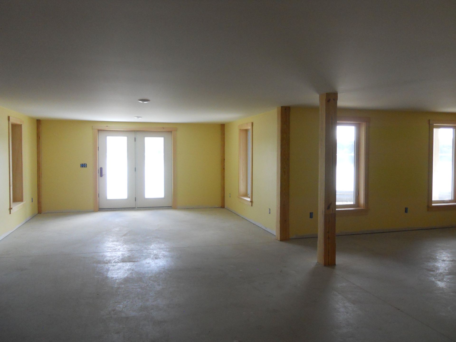 An empty room with yellow walls and white doors