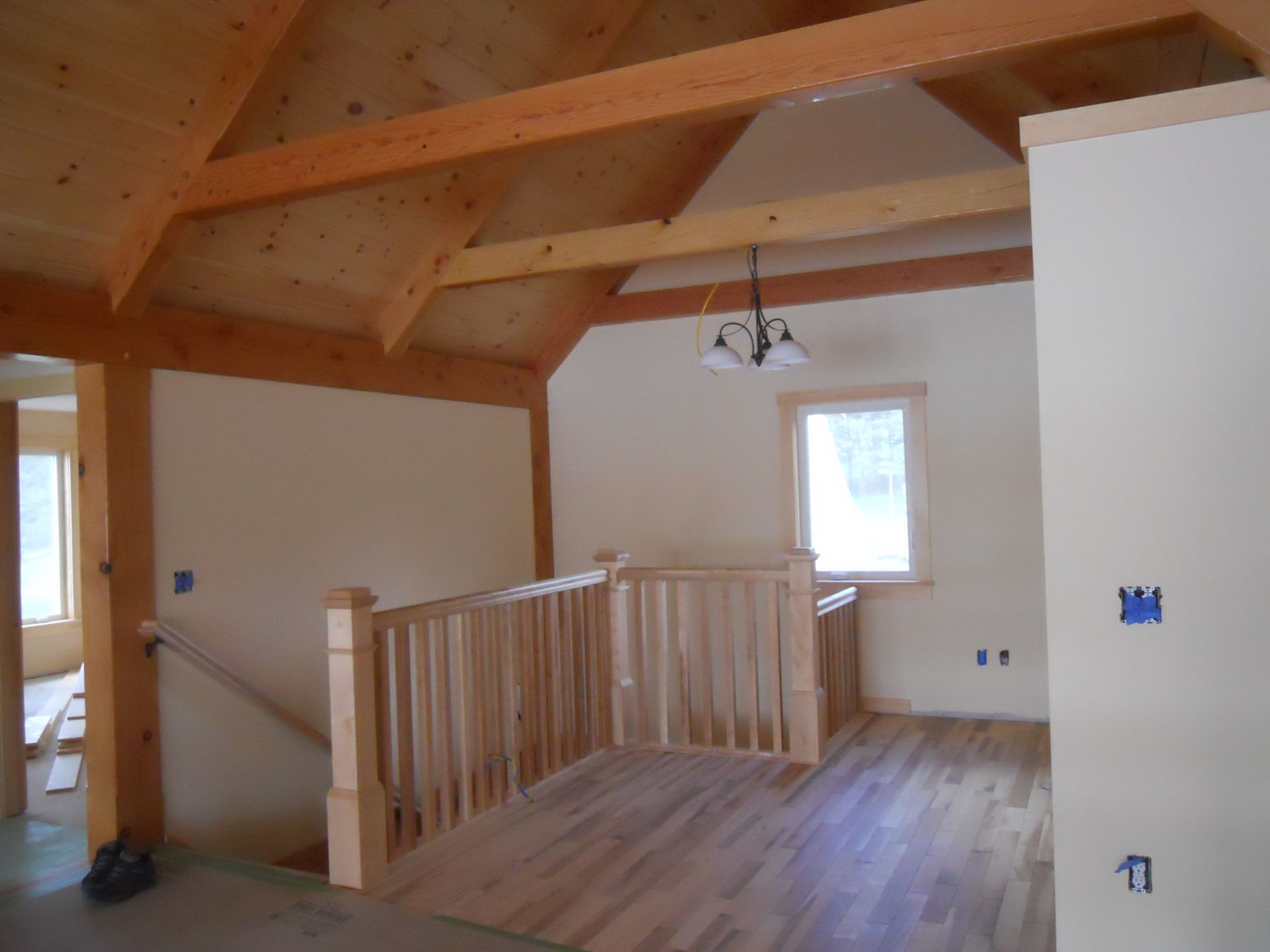 An empty room with a wooden railing and a window