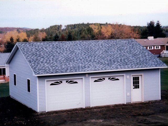 A garage with a blue roof and white doors