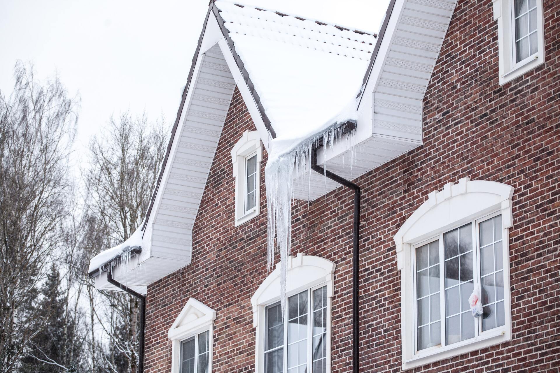 an ice dam forms on the roof of a brick home in Vermont during winter