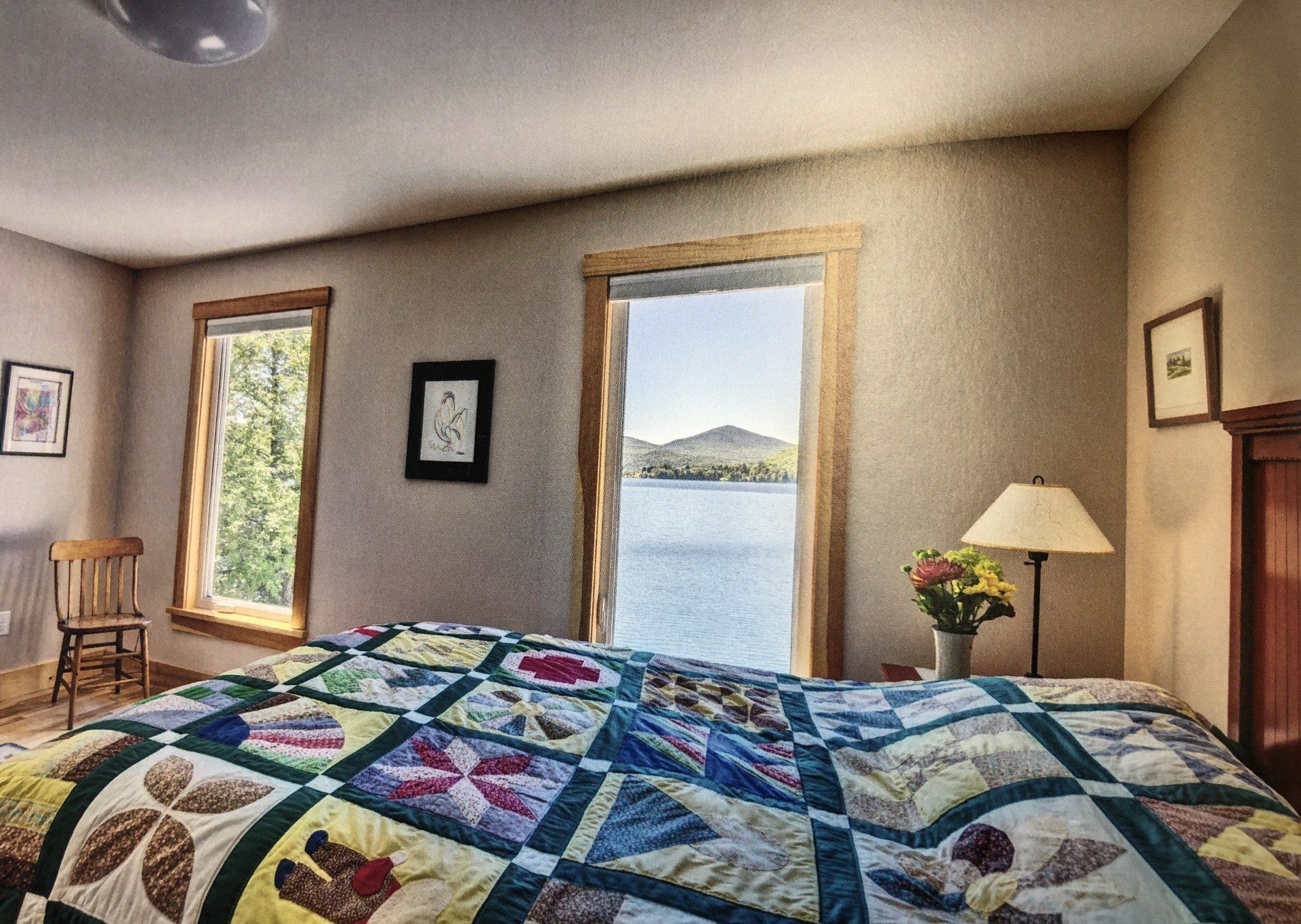 A bedroom with a large quilt on the bed