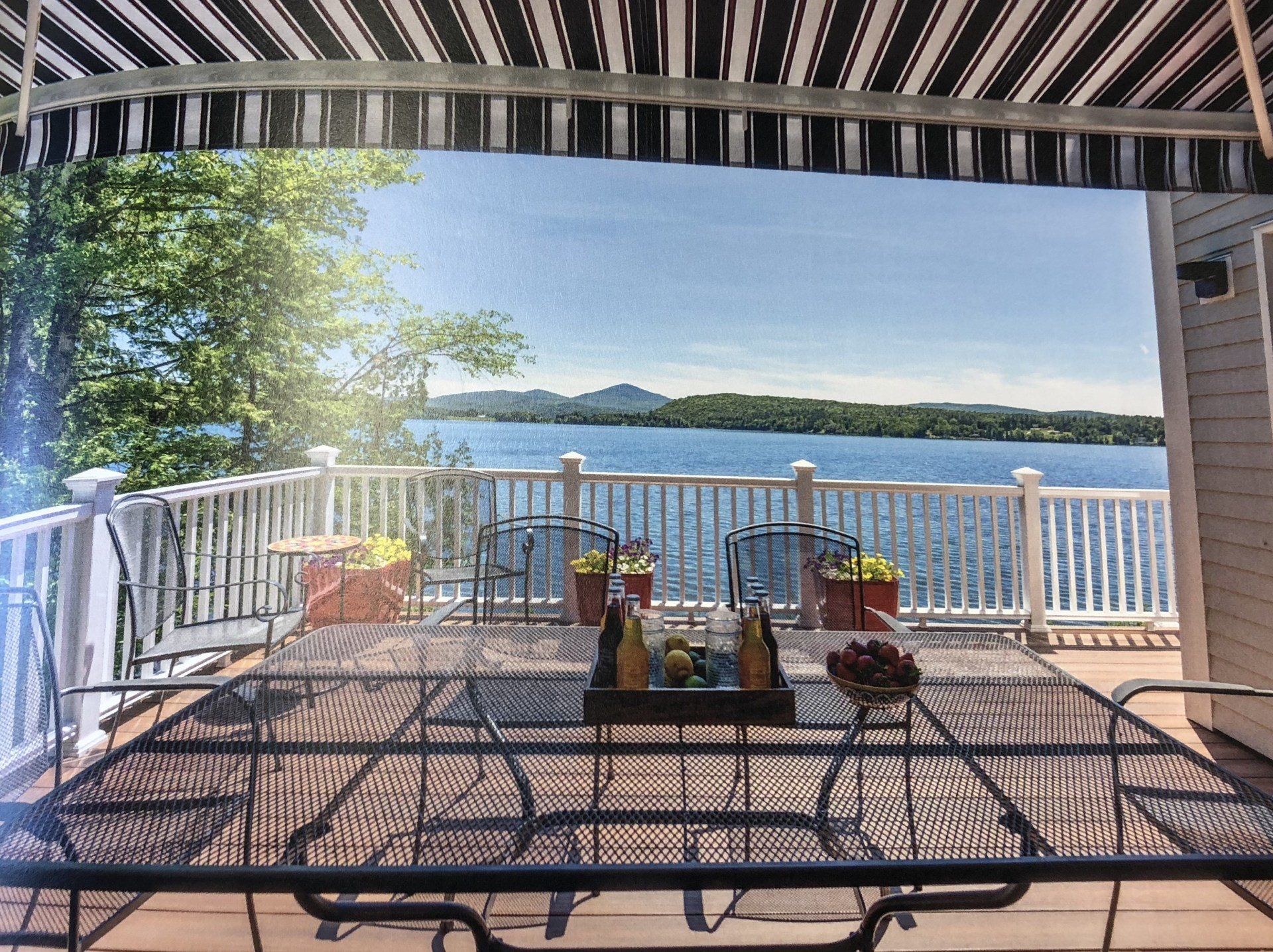 A patio with a table and chairs overlooking a lake