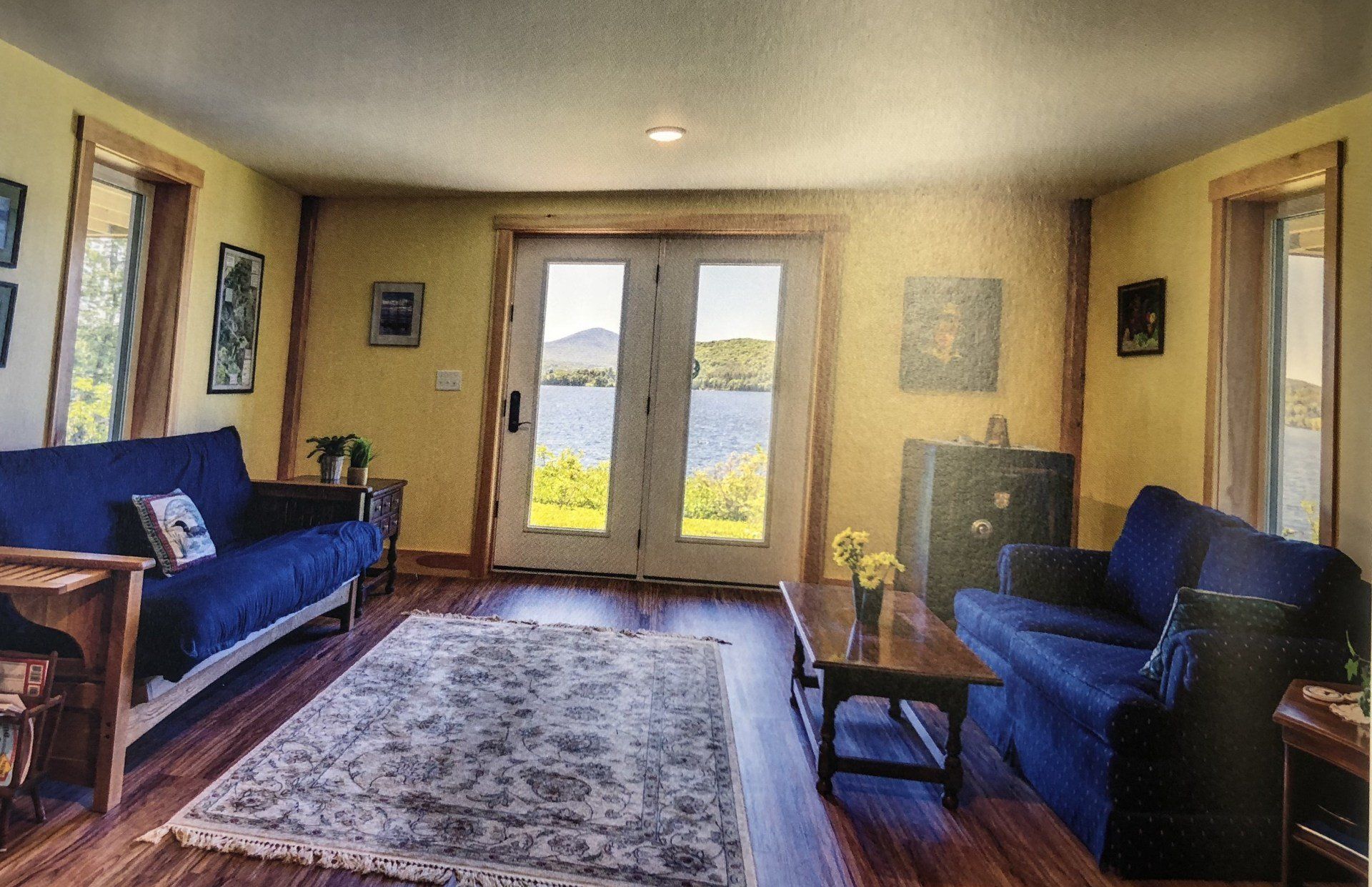 A living room with a blue couch and a white rug