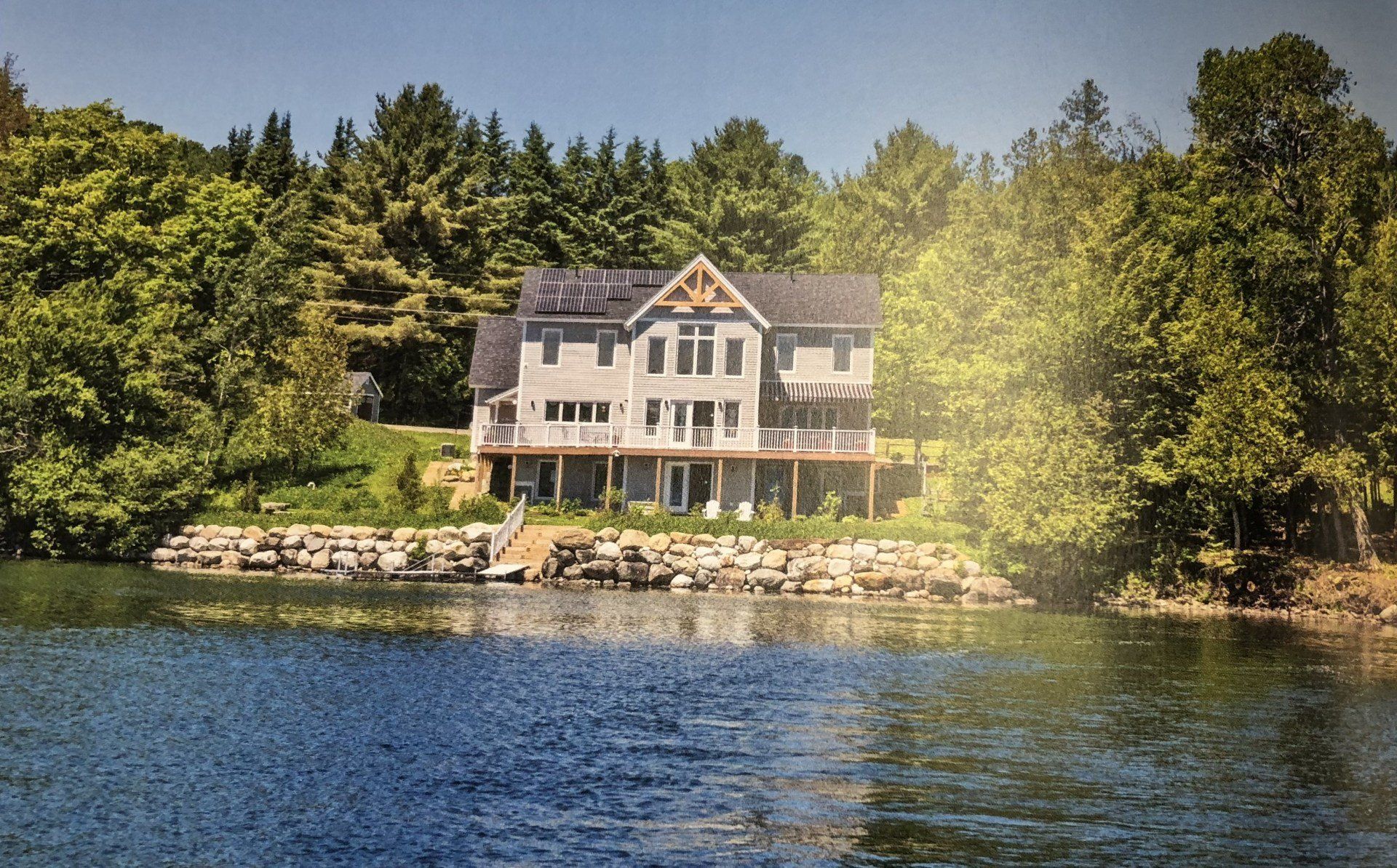A large house sits on the shore of a lake