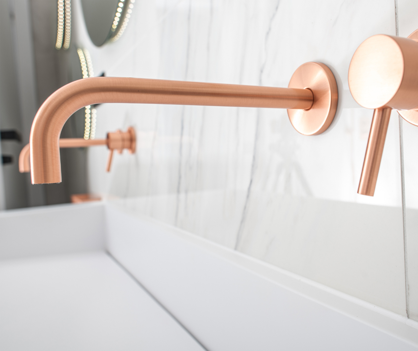 A bathroom with two copper faucets on the wall