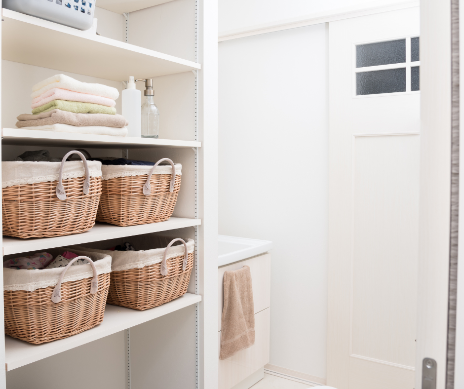 A bathroom with wicker baskets on the shelves.