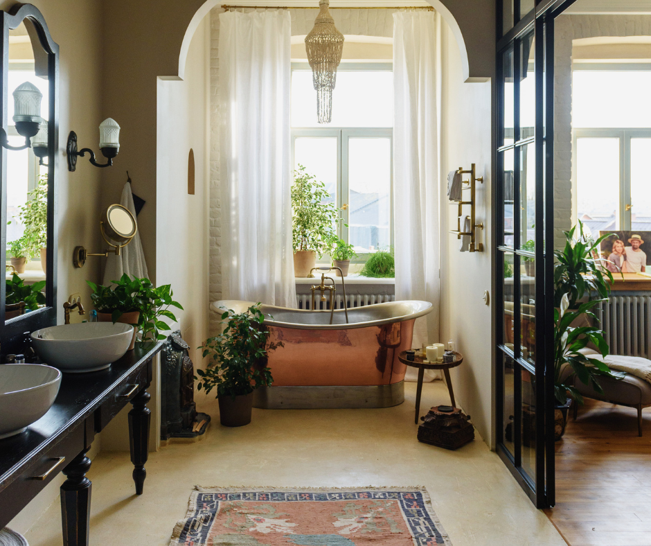 A bathroom with a copper tub , sinks , mirrors and a rug surrounded by plants