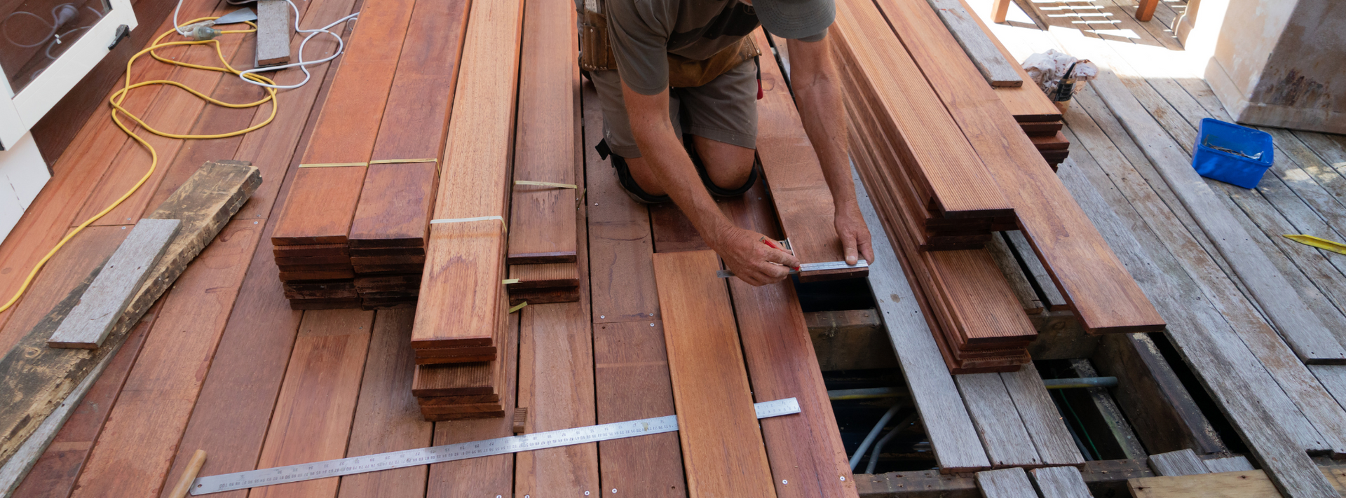 A Tanguay Homes contractor installing hardwood decking material on a Vermont home.