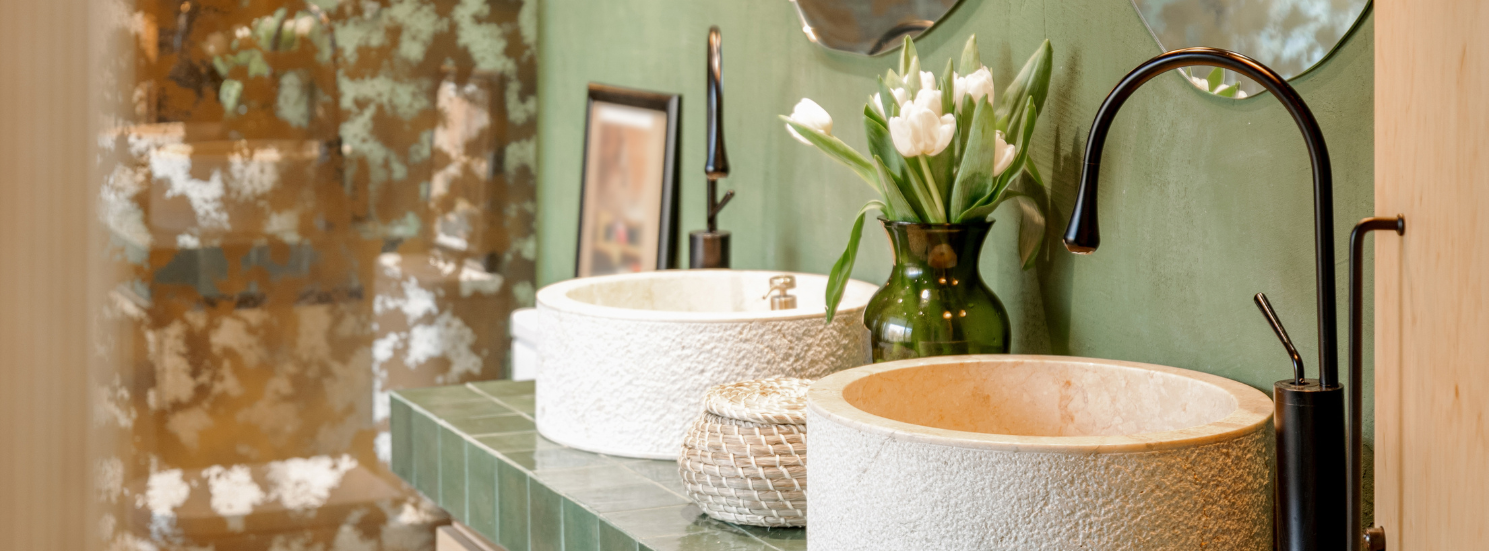 A bathroom with two sinks and a vase of flowers.