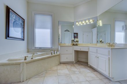 tiled bathroom with large vanity and large mirror