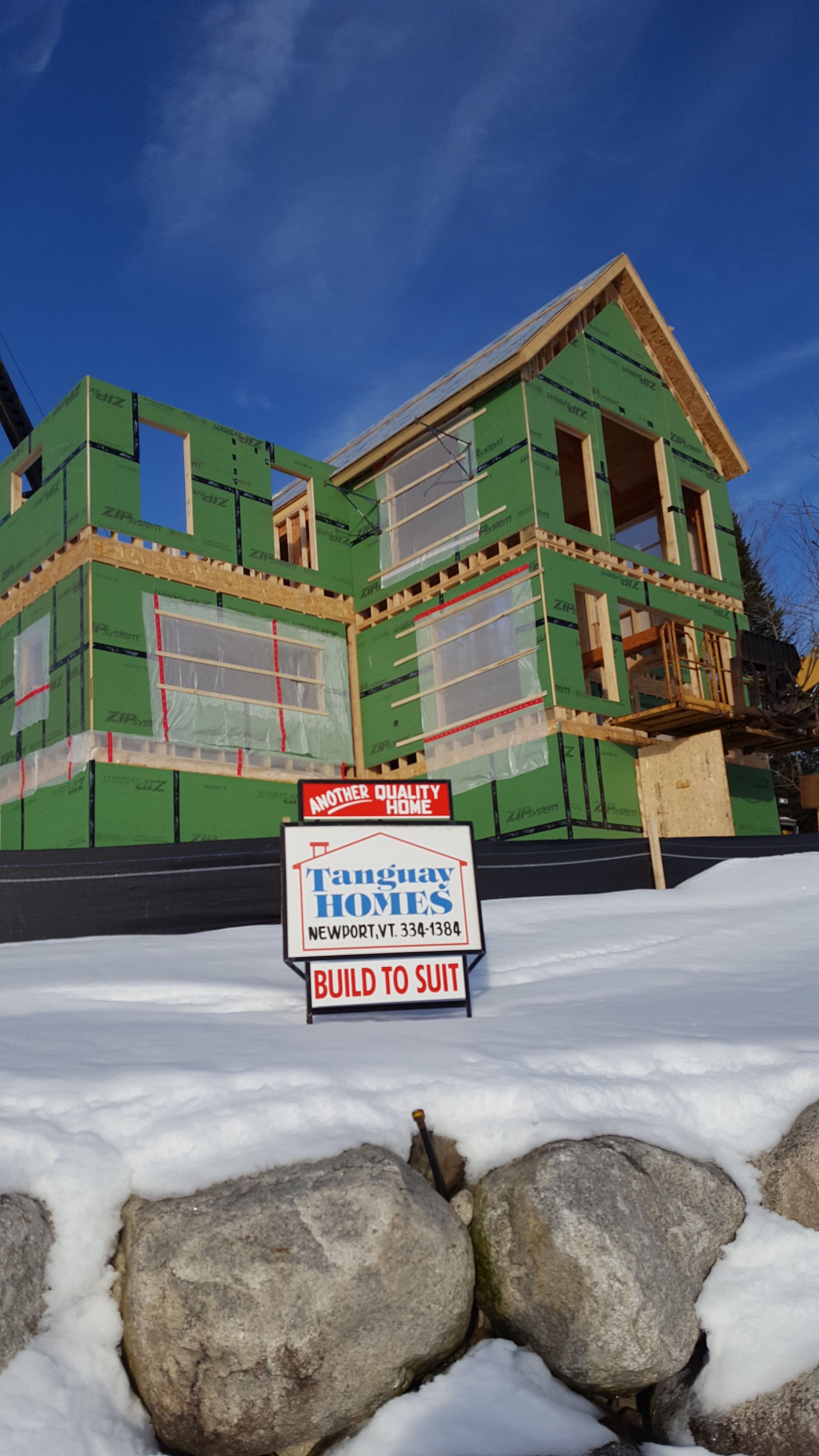 A house under construction with a for sale sign in front of it