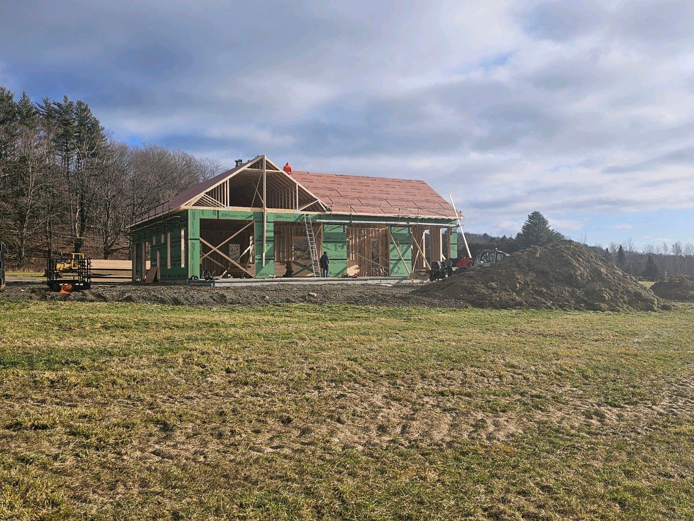 A Derby Vermont home with three custom post and beam porch roofs during construction by Tanguay Homes, a Vermont Contracting company