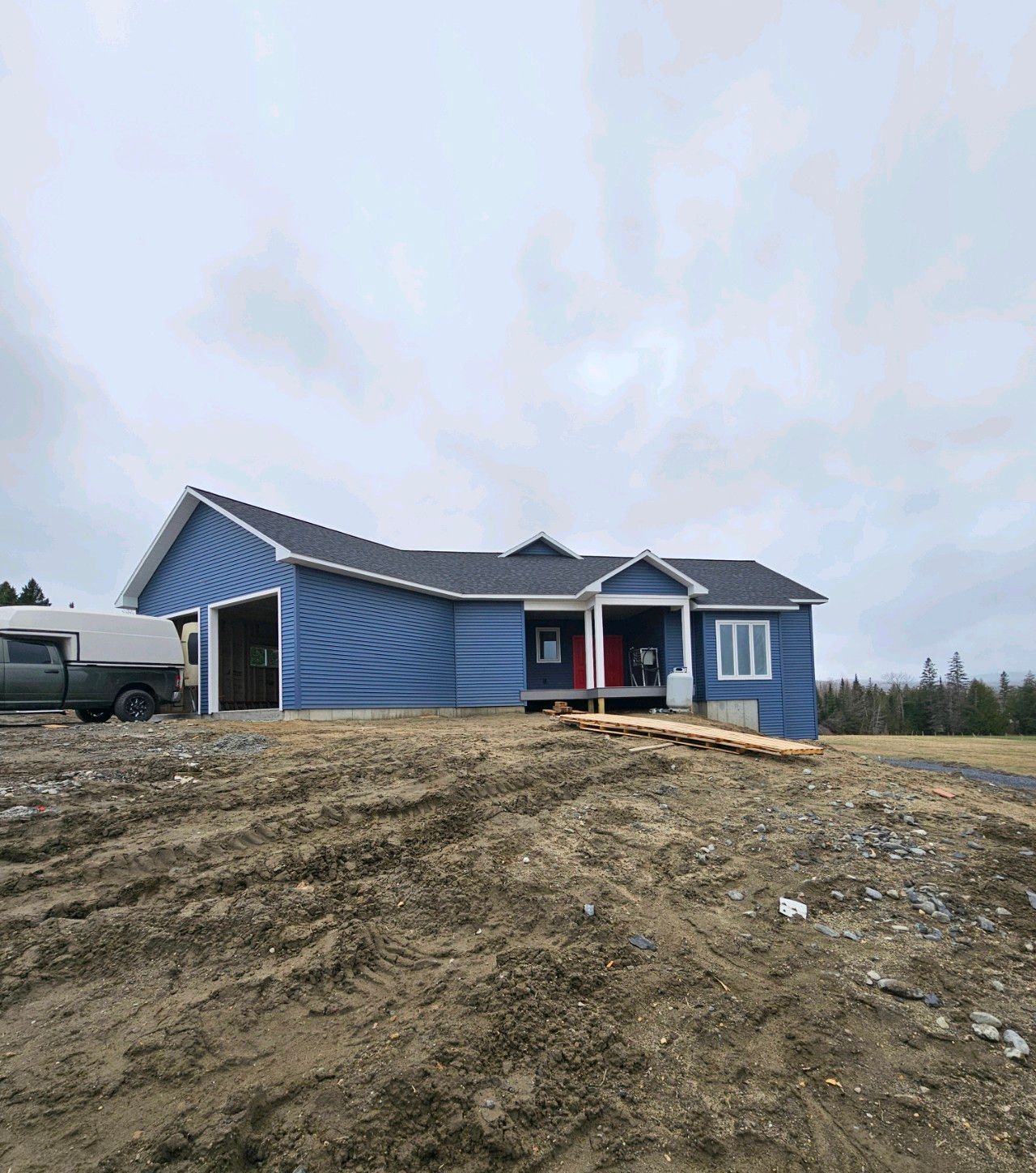 A blue house with a truck parked in front of it