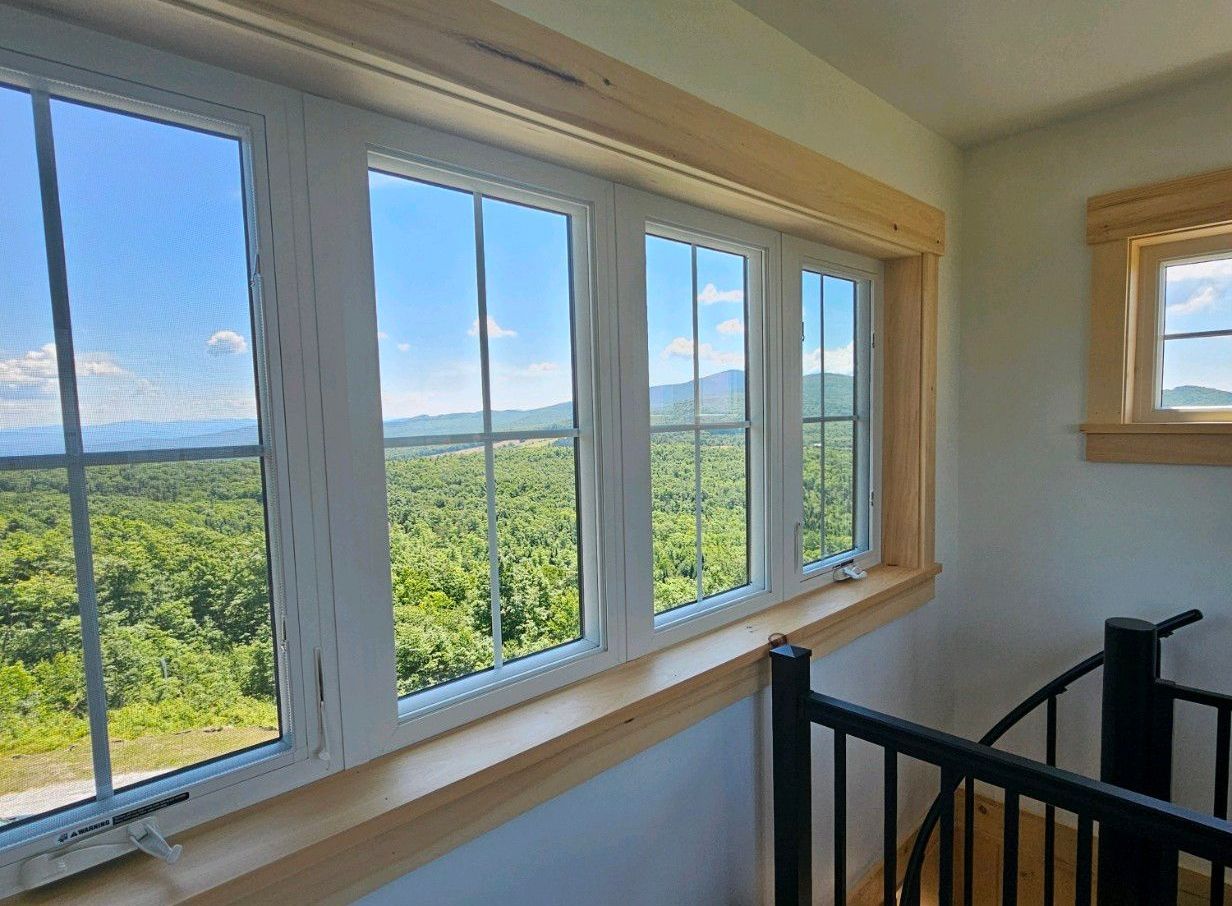A window with a view of a forest and mountains