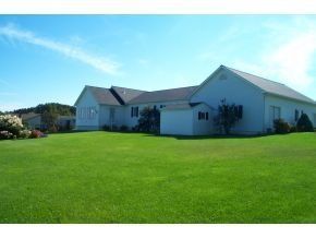 A large white house with a large lawn in front of it