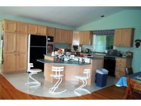 A kitchen with wooden cabinets and a black refrigerator