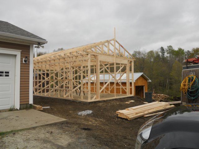 A car is parked in front of a garage under construction
