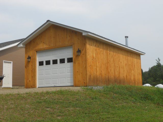 A wooden garage with a white garage door