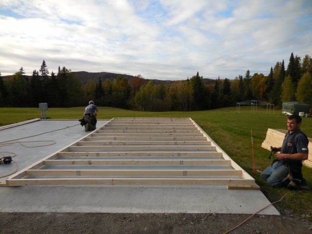 A man is kneeling in front of a wooden floor