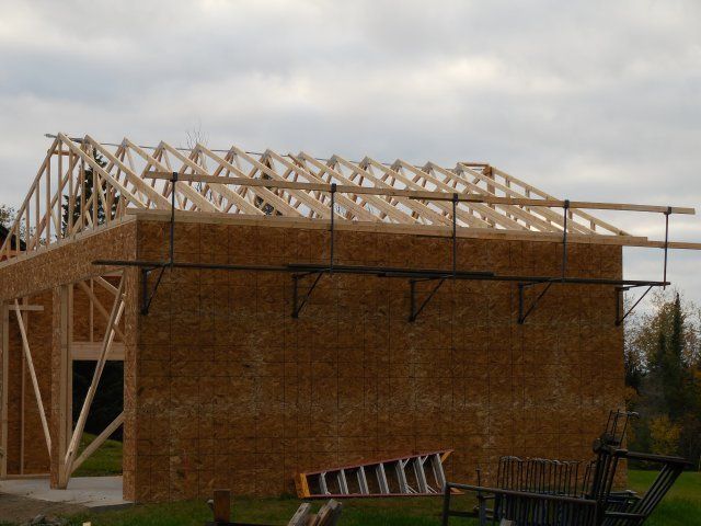 A ladder sits in front of a building under construction