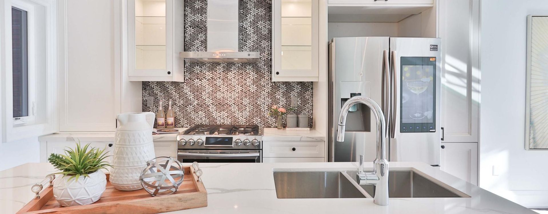 A kitchen with a sink, refrigerator, stove and microwave.