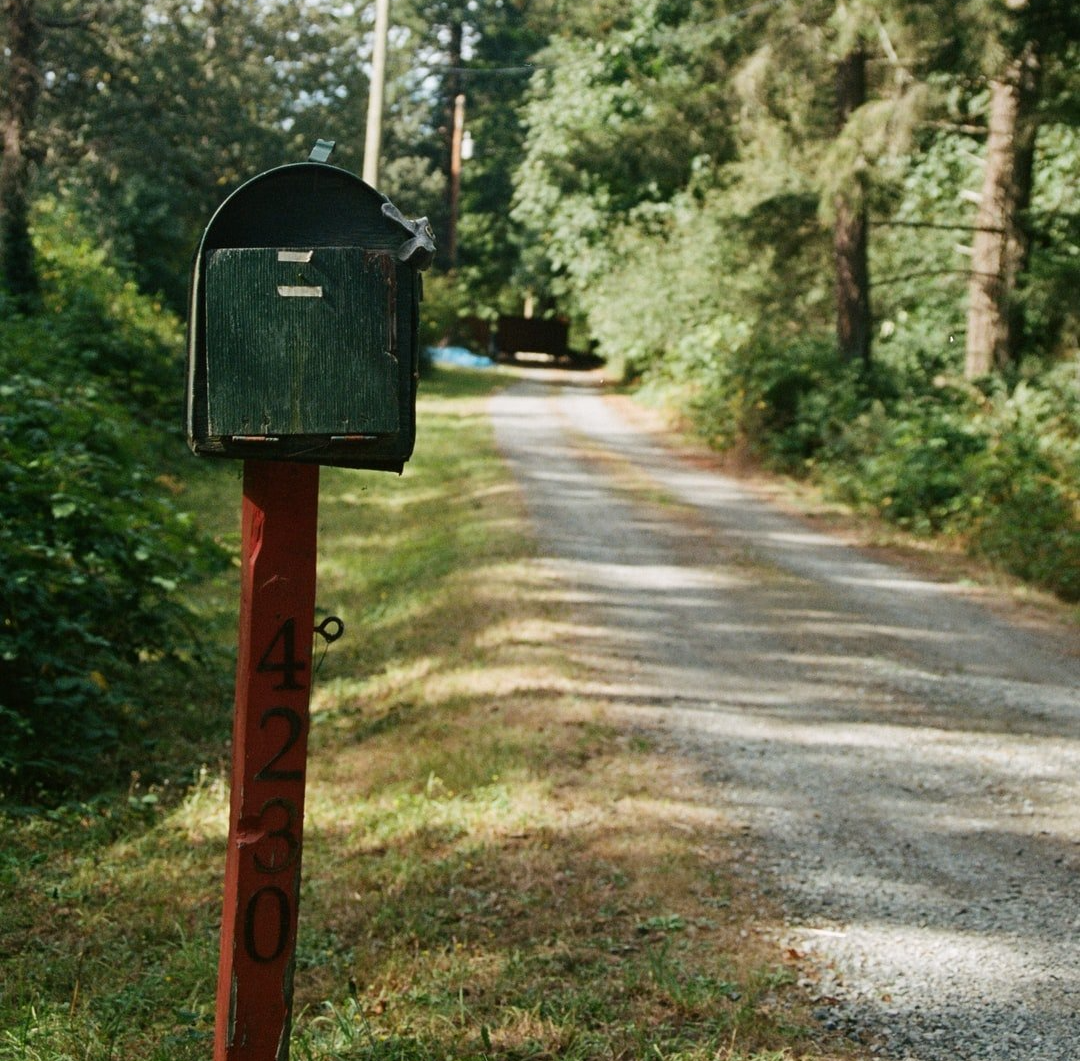 green mailbox with red post