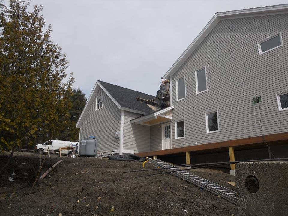 A man is working on the roof of a house