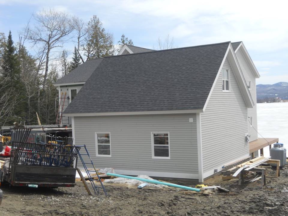 A truck is parked in front of a house that is being built