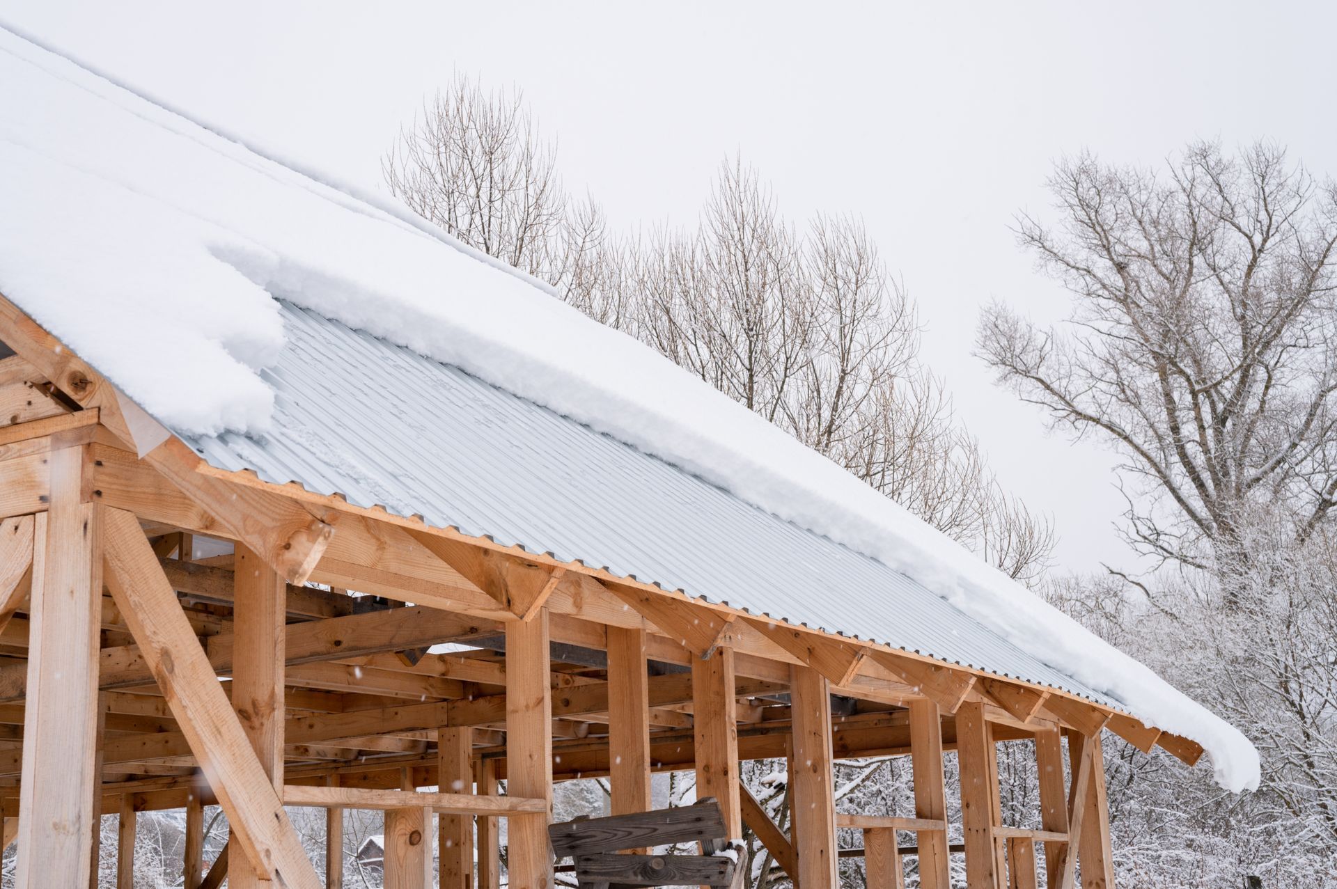 The roof of a building under construction is covered in snow